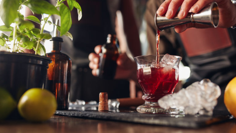 Bartender preparing fresh negroni cocktail