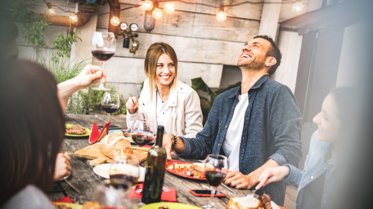 Young friends having fun drinking red wine on balcony at house dinner party – Happy people eating bbq food at fancy alternative restaurant together – Dining lifestyle concept on desaturated filter