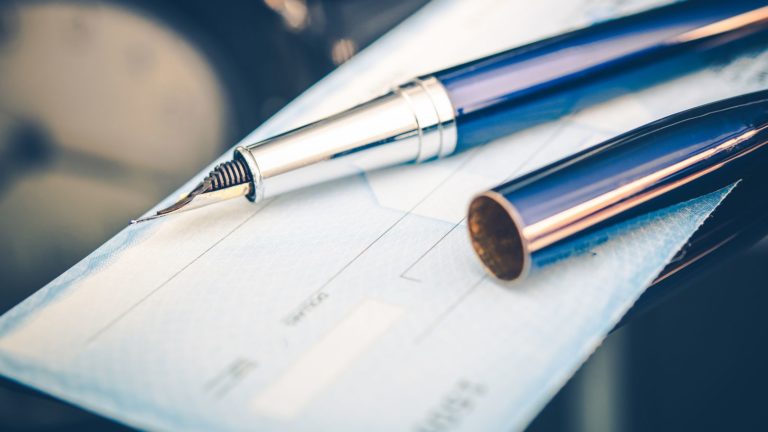 Issuing Payment by Check by Using Elegant Fountain Pen. Executive Desk Closeup.