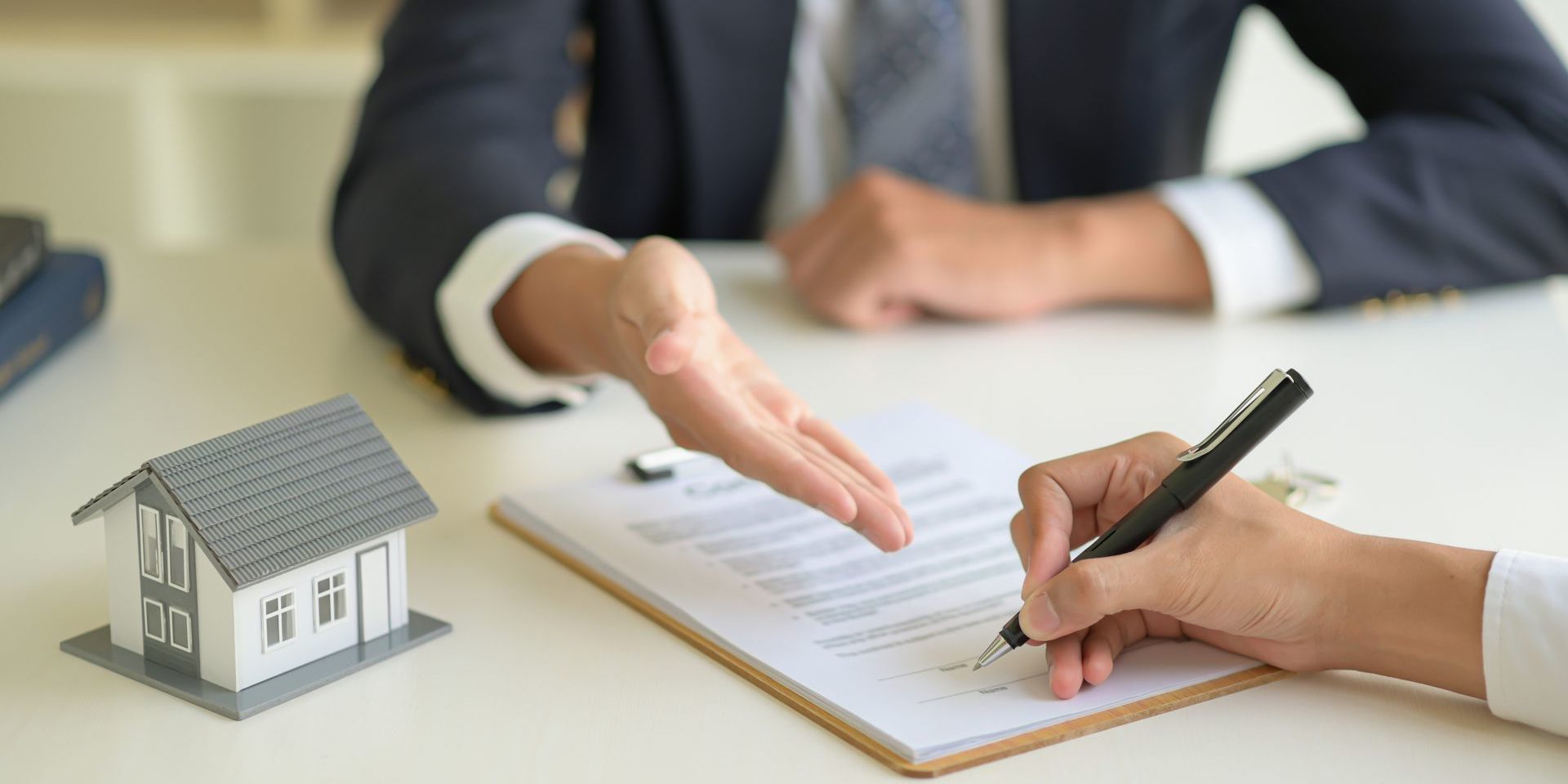 Signing a home purchase contract between the house broker and the client.